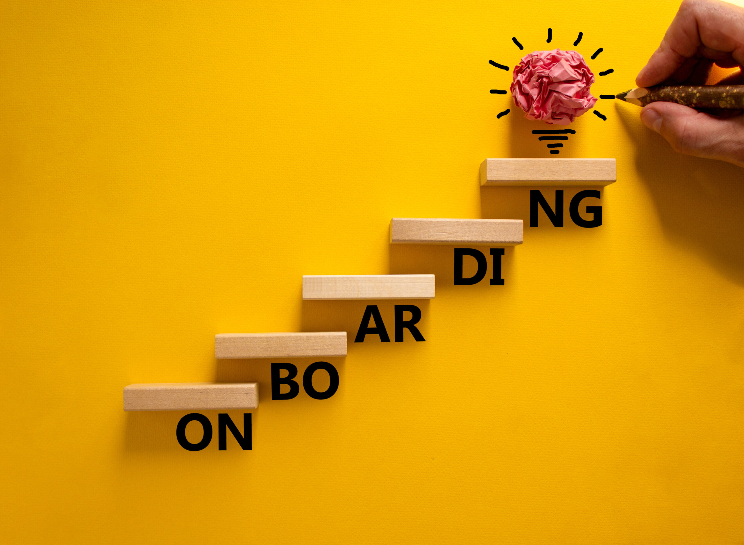 Crumpled pink paper lightbulb idea above wooden staircase with partial words, symbolizing ServiceNow onboarding strategy.