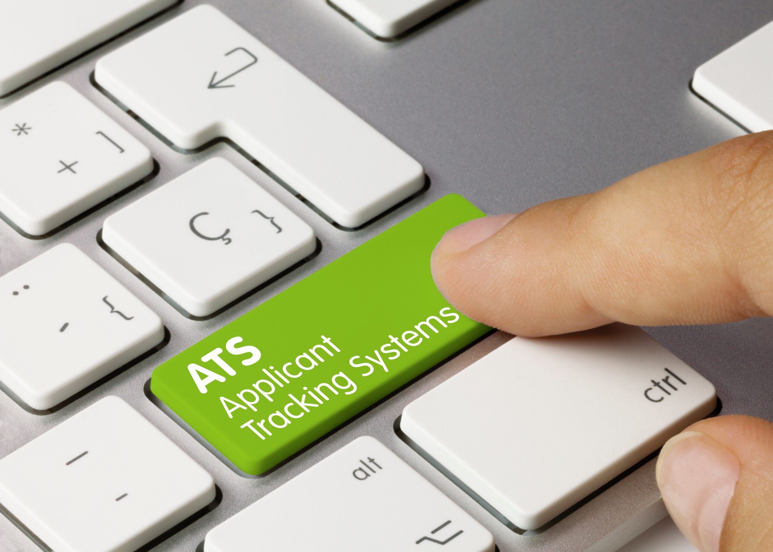 Finger pressing a green 'ATS Applicant Tracking Systems' button on a keyboard