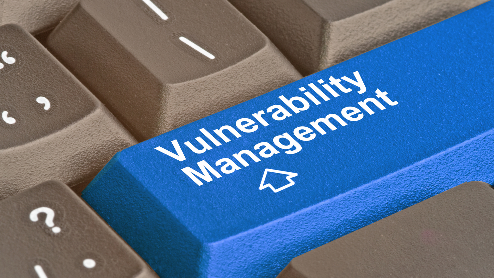 Blue keyboard key labelled Vulnerability Management sitting among beige keys, with a cursor arrow icon beneath the text